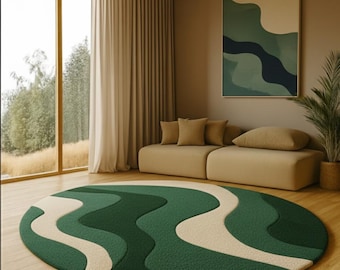 May include: A round, green and beige area rug with a wavy pattern. The rug is on a hardwood floor in a living room setting. The room also features a beige sofa, a large window, and a piece of abstract art on the wall.
