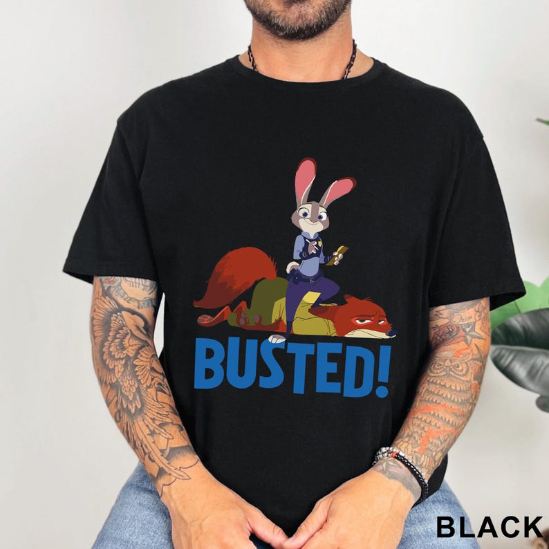 May include: Black t-shirt with a cartoon image of a rabbit police officer standing on a fox, with the word "BUSTED!" in blue. The shirt also has the word "BLACK" printed at the bottom.