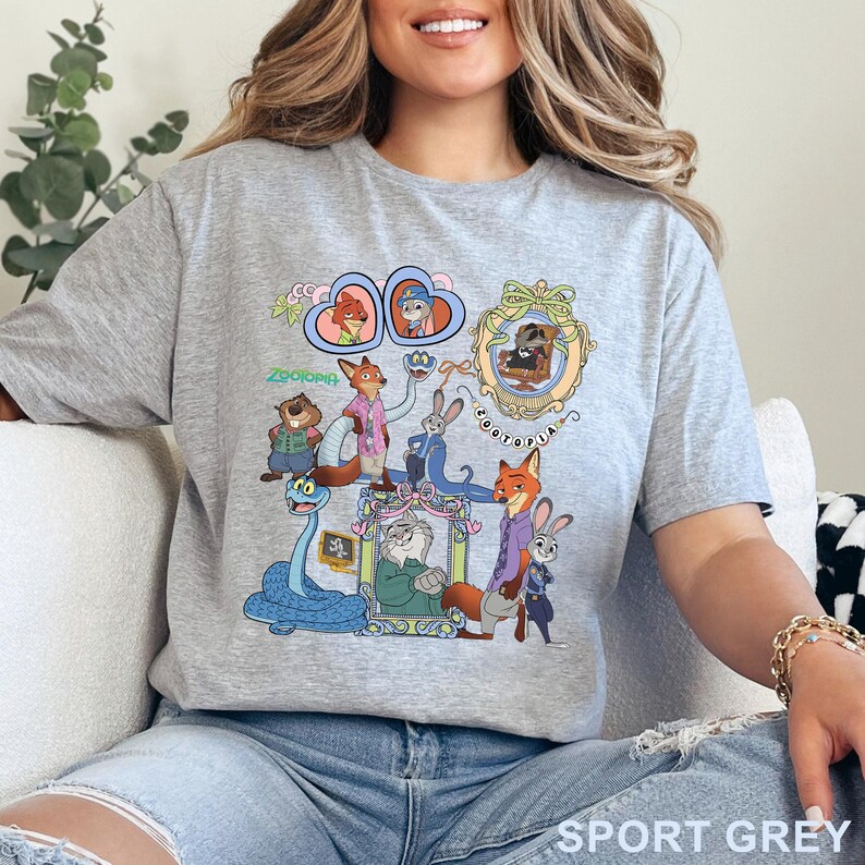 Puede incluir: Camiseta gris deportivo con un gr&aacute;fico colorido de personajes de la pel&iacute;cula animada Zootopia. El dise&ntilde;o incluye varios personajes animales en marcos y el texto "Zootopia".