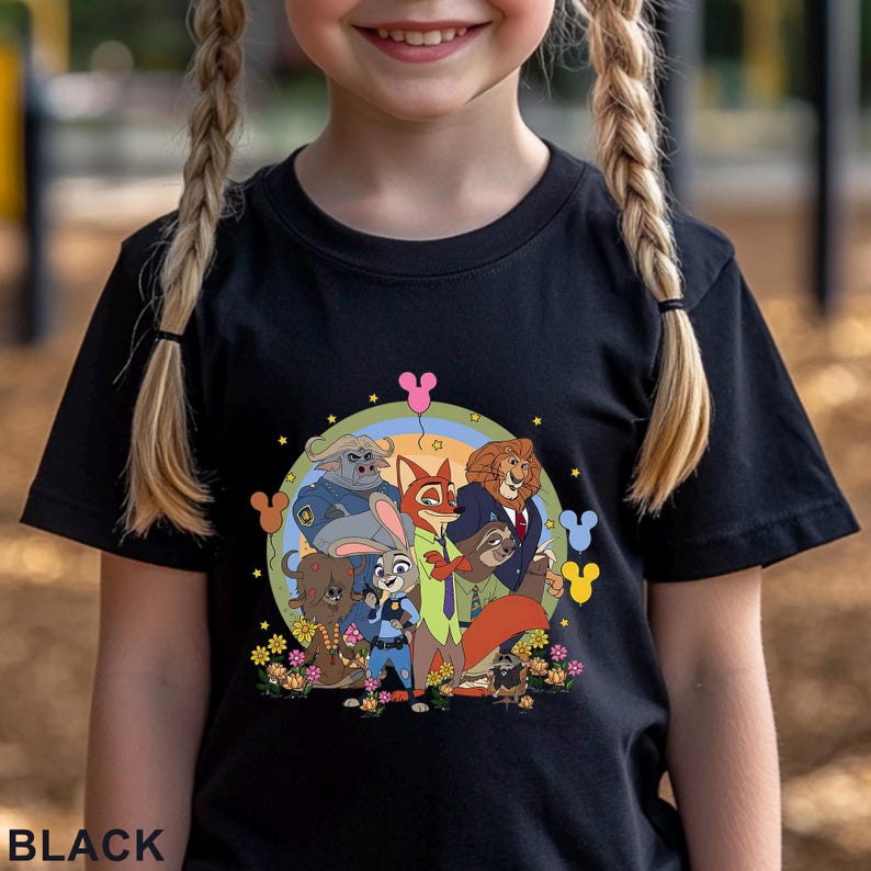 May include: Black t-shirt featuring a colorful graphic of characters from the animated movie Zootopia. The design includes Judy Hopps, Nick Wilde, and other characters, surrounded by flowers and a rainbow. The word "BLACK" is printed at the bottom.