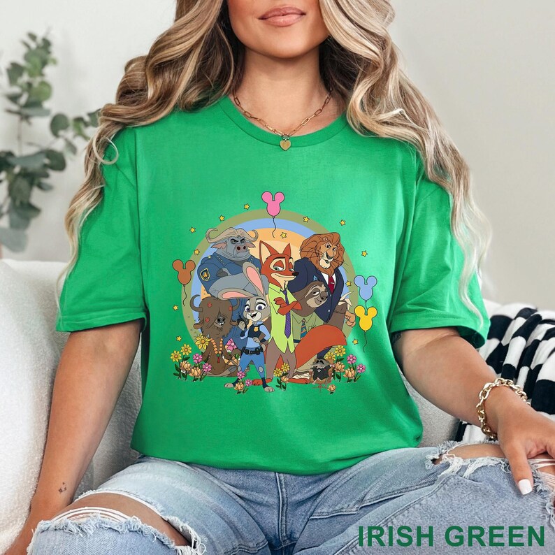 May include: A green t-shirt featuring a colorful graphic of cartoon animal characters. The design includes a rainbow, flowers, and Mickey Mouse-shaped balloons. The text "IRISH GREEN" is at the bottom of the shirt.