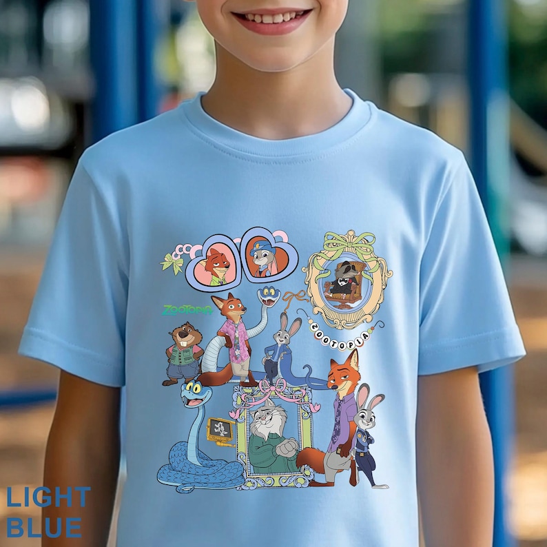 Puede incluir: Camiseta azul claro con un gr&aacute;fico colorido de personajes de la pel&iacute;cula animada Zootopia. El dise&ntilde;o incluye varios personajes de animales y la palabra "Zootopia". La camiseta est&aacute; hecha de un material suave.