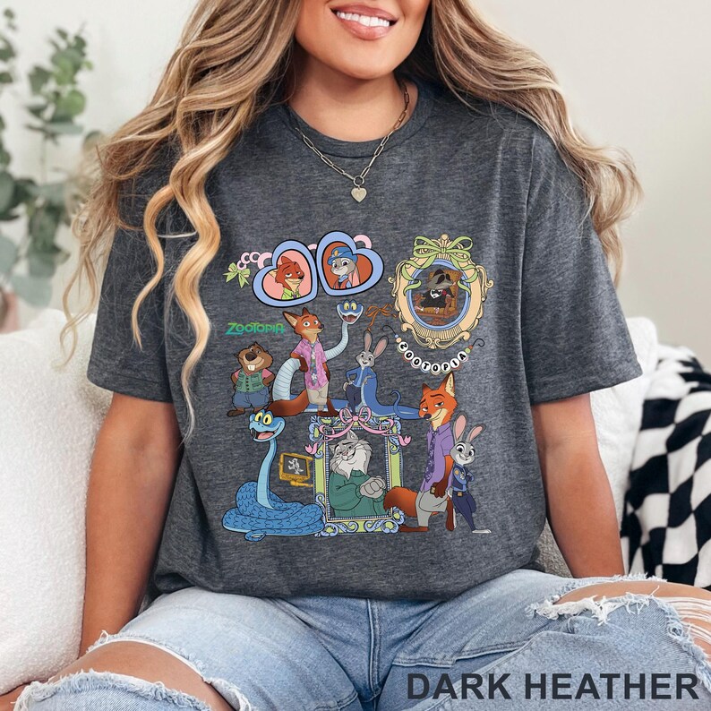 Puede incluir: Camiseta gris oscuro con un gr&aacute;fico colorido de personajes de la pel&iacute;cula animada "Zootopia". El dise&ntilde;o incluye retratos enmarcados y varios personajes de animales. Tambi&eacute;n es visible el texto "Zootopia".