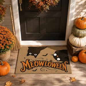 Peut inclure: Un paillasson rectangulaire beige orné de deux chats noirs aux yeux écarquillés et du texte orange MEOWLOWEEN écrit dans une police stylisée. Le motif comprend de petites chauves-souris noires et des étoiles dispersées sur la surface.