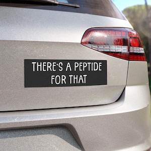 May include: A rectangular black bumper sticker applied to the silver trunk of a vehicle. The sticker features white sans-serif text that reads, "THERE'S A PEPTIDE FOR THAT," arranged in two lines with a clean, modern, and highly legible font style.