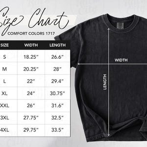 Op de afbeelding: Een zwart t-shirt met een maattabel, inclusief afmetingen in cm voor breedte en lengte. De tabel vermeldt maten S t/m 4XL, waarbij de kleinste maat een breedte heeft van 46,36 cm en een lengte van 67,56 cm. Het t-shirt is voorzien van het label "Comfort Colors 1717."