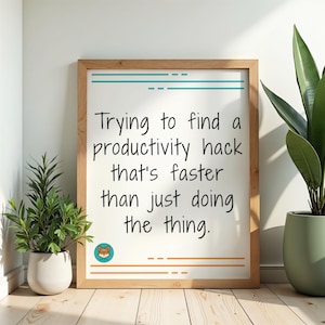 May include: Wooden framed print with the text "Trying to find a productivity hack that's faster than just doing the thing." The print has a white background with teal and orange accents. A fox logo is in the bottom left corner.