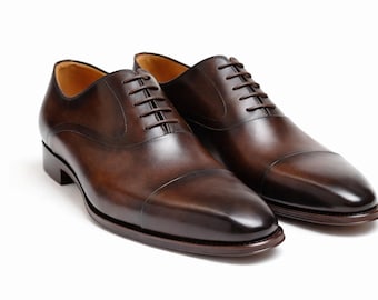 Zapatos Oxford de vestir con puntera de cuero marrón hechos a mano: un clásico atuendo formal de negocios.