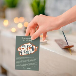 May include: A green card with the text "Thank you for resting" and an illustration of kitchen utensils and plants is held by a hand. An incense stick is burning nearby. The card's message encourages rest and healing.