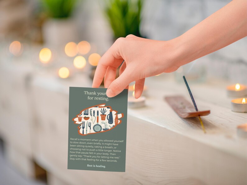 May include: A green card with the text "Thank you for resting" and an illustration of kitchen utensils and plants is held by a hand. An incense stick is burning nearby. The card's message encourages rest and healing.