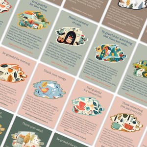 May include: A collection of gratitude cards with various illustrations and text. Each card features a unique design with phrases like "Feel grateful for your home" and "Thank a moment of calm." The cards have a soft, pastel color palette.