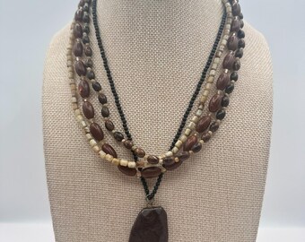 Collar vintage de los años 80 con múltiples hilos, cuentas en tonos tierra y piedras de imitación.