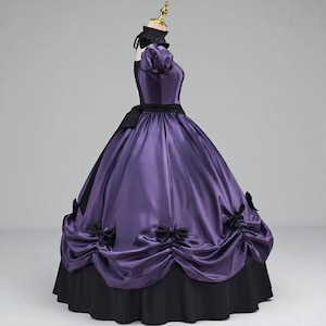 May include: A purple satin ball gown with a black bodice, short sleeves, and a black ribbon belt. The skirt features black bows and a black underskirt. The dress is displayed on a mannequin.