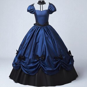 May include: A blue and black ball gown with a satin finish. The dress features a fitted bodice, short puffed sleeves, and a full skirt with black bows. A black choker is included.