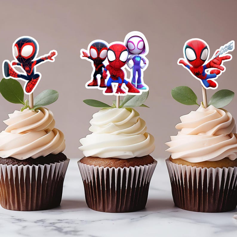 May include: Three cupcakes with white and pale brown frosting, each topped with a different Spider-Man character cutout on a wooden stick. The cupcakes sit on a white surface.