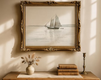 May include: A framed watercolor painting of a sailboat on the water, displayed above a wooden table. The painting has a gold ornate frame. A vase with dried flowers, stacked books, and a brass candlestick are on the table.