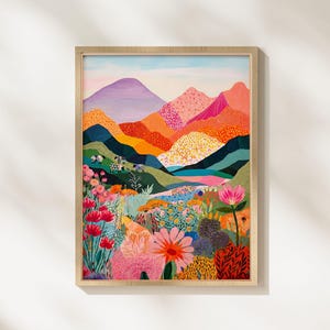 Könnte beinhalten: Ein gerahmter Kunstdruck mit einer farbenfrohen Landschaft. Das Kunstwerk zeigt eine Bergkette mit Gipfeln in Lila-, Orange- und Rosatönen. Der Vordergrund ist mit Blumen in verschiedenen Farben gefüllt, darunter Rot, Rosa und Gelb.