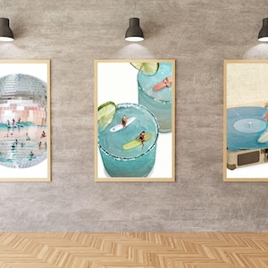 May include: Three framed wall art prints featuring surrealist collages. The left print shows a disco ball filled with swimmers and surfers. The center print depicts surfers on lime-garnished cocktails. The right print shows a surfer on a record player.