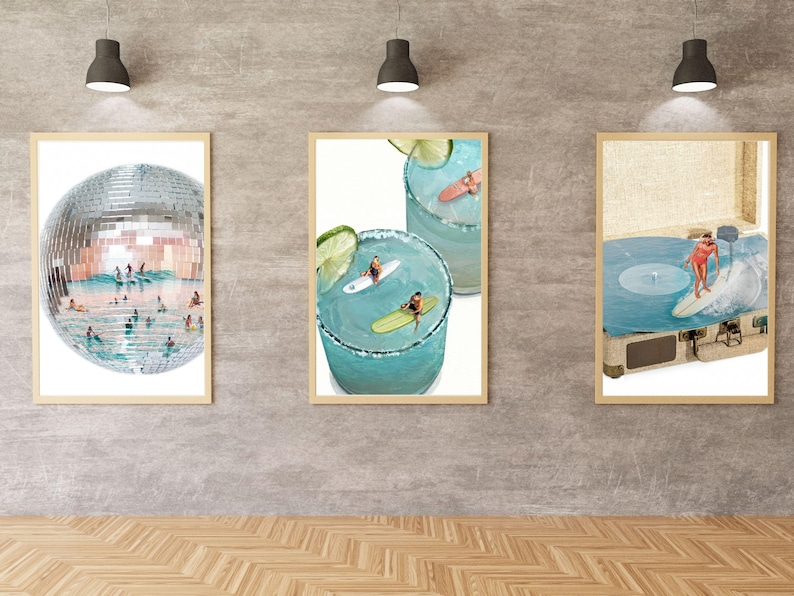 May include: Three framed wall art prints featuring surrealist collages. The left print shows a disco ball filled with swimmers and surfers. The center print depicts surfers on lime-garnished cocktails. The right print shows a surfer on a record player.