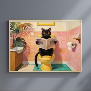 Könnte beinhalten: Gerahmter Kunstdruck, der eine schwarze Katze mit orangefarbenen Augen zeigt, die eine Zeitung liest, während sie auf einer gelben Toilette in einem rosa gefliesten Badezimmer sitzt. Waschbecken, Pflanze und Toilettenpapierrolle sind ebenfalls zu sehen. Vintage-Stil.