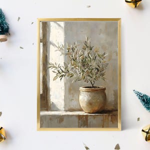 Könnte beinhalten: Ein gerahmter Kunstdruck mit einem Olivenbaum in einem Topf in einem neutral getönten Innenraum. Das Kunstwerk hat einen goldenen Rahmen und ist von kleinen dekorativen Weihnachtsbäumen und goldenen Glocken auf weißem Hintergrund umgeben.