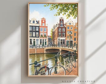 May include: A framed watercolor print of a canal scene in Amsterdam, featuring colorful buildings, a bridge, and bicycles. The artwork has a light wooden frame and the text "NEUVIA CREATIVE" in the bottom right corner.