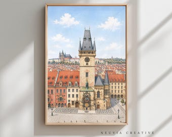 May include: Watercolor print of a European city scene featuring a tall clock tower, red-tiled roofs, and a distant castle under a blue sky with fluffy clouds. The artwork is framed in a light wood frame.
