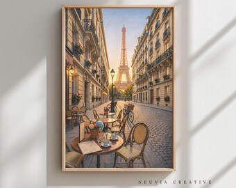 May include: A framed print of a Parisian street scene featuring the Eiffel Tower at sunset. The image shows a cobblestone street with outdoor cafe tables and chairs. A bicycle is parked near the tables, and flowers are on the tables.