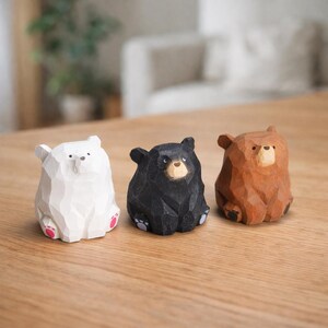 Pode incluir: Tr&ecirc;s estatuetas de urso de madeira em branco, preto e castanho. O urso branco tem detalhes rosa nos p&eacute;s. O urso preto tem um rosto castanho claro. O urso castanho tem um acabamento em madeira natural. Cada urso &eacute; esculpido com um design facetado.