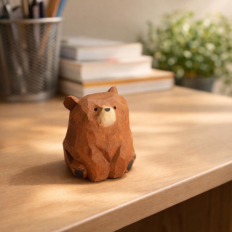 Pode incluir: Uma estatueta de urso de madeira entalhada &agrave; m&atilde;o com uma superf&iacute;cie texturizada detalhada. O urso &eacute; castanho com um focinho de cor mais clara e olhos e patas pretas. A estatueta est&aacute; numa superf&iacute;cie de madeira.