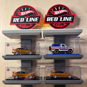 Könnte beinhalten: Eine Sammlung von Hot Wheels Red Line Club Modellautos. Die Sammlung umfasst einen goldenen 1995 BMW M3 LTW, einen blau-weißen 1985 Ford Bronco, einen hellblauen Porsche 959 und einen gelben Porsche, jeweils in einer transparenten Vitrine.
