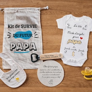 Peut inclure: Ensemble de cadeaux pour futur papa. Il comprend un sac en toile, un bavoir, un ouvre-bouteille, un dessous de verre, un body bébé et une sucette. Les articles sont blancs, jaunes et noirs.