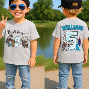 May include: A gray t-shirt with the text "Birthday" and a graphic of characters from the movie Frozen. The number "5" and the name "William" are on the back of the shirt. The child is wearing blue jeans and black sneakers.