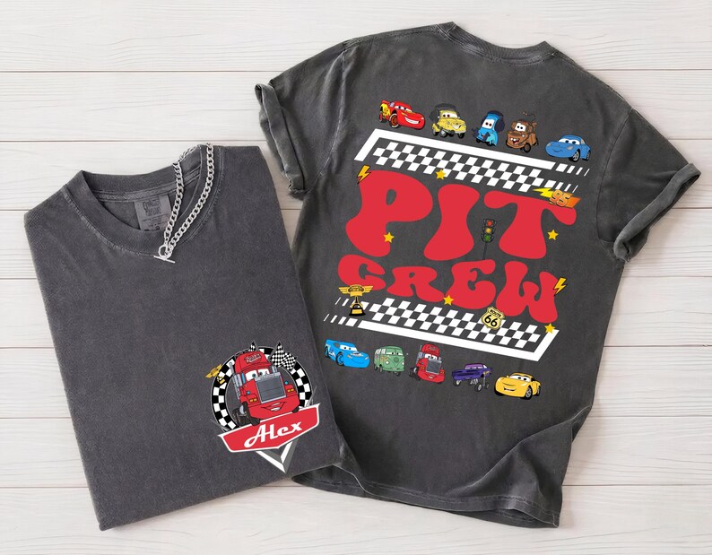 Puede incluir: Dos camisetas gris carb&oacute;n. Una presenta un gr&aacute;fico de coche de carreras con el nombre "Alex" y una bandera a cuadros. La otra tiene "Pit Crew" en letras rojas con ilustraciones de coches de carreras y un dise&ntilde;o de bandera a cuadros.