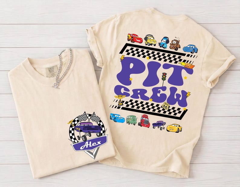Puede incluir: Dos camisetas beige con gr&aacute;ficos tem&aacute;ticos de coches. Una camiseta presenta un coche morado con banderas y el nombre "Alex". La otra camiseta tiene "PIT CREW" en morado con ilustraciones de coches y un dise&ntilde;o de bandera a cuadros.