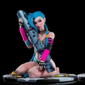 Puede incluir: Figura detallada de un personaje femenino con cabello azul y un arma. La figura está arrodillada sobre una base a cuadros, con un fondo negro. El personaje lleva un bikini y tiene detalles en rosa y negro.