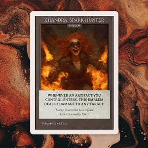 May include: A rectangular trading card titled Chandra, Spark Hunter, featuring an illustration of a person with red hair and goggles surrounded by flames. The card text reads: Whenever an artifact you control enters, this emblem deals 3 damage to any target. Every invention has a flaw. Hers is usually fire.