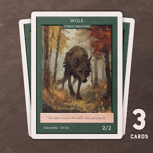 May include: Three trading cards featuring a wolf illustration in a forest setting. The cards have a green border and white edges. Text on the cards reads "WOLF", "TOKEN CREATURE", and "You don't tame the wild. You survive it." The cards are labeled "2/2" and "TokenFella RT136".