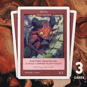 Peut inclure: Trois cartes à collectionner représentant un diable rouge avec des cornes, sur fond de pierres. Les cartes ont une bordure blanche et le texte "DEVIL" et "TOKEN CREATURE". Le texte "WHEN THIS CREATURE DIES, IT DEALS 1 DAMAGE TO ANY TARGET" est également visible.