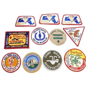 May include: A collection of eleven embroidered Boy Scouts of America patches in various shapes and colors. The patches feature text including Columbia-Montour, Greater Boston, Patrol Leader, Max I. Silber NESA, Gulf Ridge, and Camp Nihan Reservation.