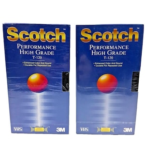 May include: Two blue boxes of Scotch T-120 Performance High Grade VHS tapes. Each box features the Scotch logo in gold, a large orange and red sphere, and text that reads "Enhanced Color And Sound" and "Durable For Repeated Use."