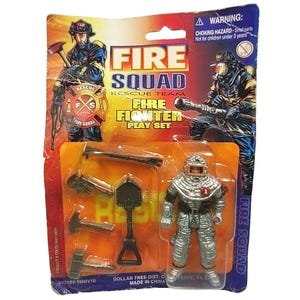 May include: A Fire Squad Fire Fighter play set in original packaging. The card features illustrations of firefighters and the text FIRE SQUAD FIRE FIGHTER PLAY SET. Inside the plastic blister pack is a silver firefighter action figure and tools.