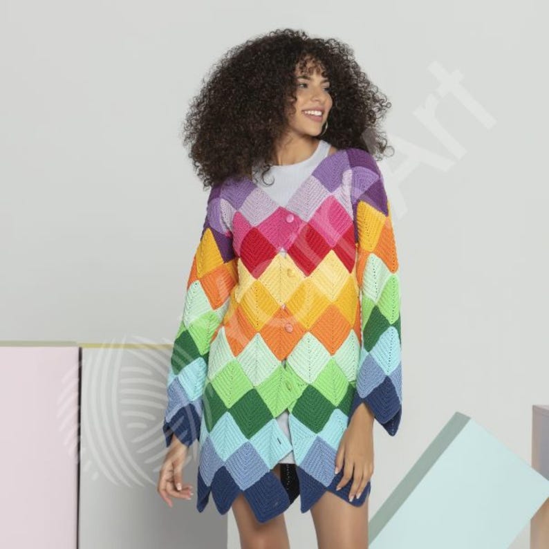 Pode incluir: Um cardig&atilde; de manga comprida com decote em V, apresentando um padr&atilde;o de losangos multicolorido e vibrante em tons de roxo, rosa, vermelho, laranja, amarelo, verde e azul. A pe&ccedil;a &eacute; feita de quadrados de croch&ecirc; e possui fecho de bot&otilde;es.