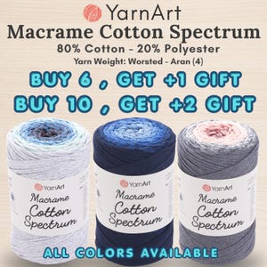 May include: Three cylindrical spools of YarnArt Macrame Cotton Spectrum yarn, composed of 80% cotton and 20% polyester with a worsted-aran weight. The spools feature gradient color transitions from light blue to dark blue and pink to gray.