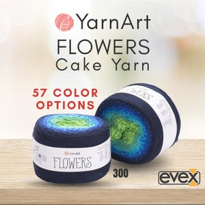 May include: Two cakes of YarnArt Flowers cake yarn featuring a gradient color transition from dark navy blue to bright green. The white product labels display the text YarnArt FLOWERS and 57 COLOR OPTIONS, with the number 300 visible.