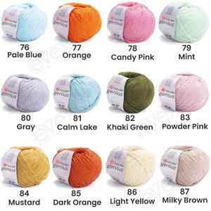 Pode incluir: Doze novelos de fio YarnArt Genius em v&aacute;rias cores, cada um com uma etiqueta de papel branca. As cores incluem azul p&aacute;lido, laranja, rosa doce, menta, cinza, lago calmo, verde c&aacute;qui, rosa p&oacute;, mostarda, laranja escuro, amarelo claro e castanho leitoso.