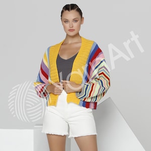 Pode incluir: Um cardig&atilde; de malha curto com um padr&atilde;o vibrante de riscas multicoloridas em tons de amarelo, vermelho, azul e branco. A pe&ccedil;a apresenta uma borda frontal canelada em amarelo s&oacute;lido, mangas compridas com punhos canelados e design aberto.