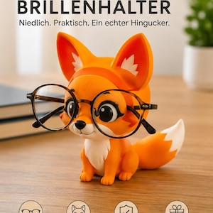 Könnte beinhalten: Ein orange-weißer Fuchs-Brillenhalter mit großen Augen, der eine runde Brille mit Schildpattmuster trägt. Der Text FUCHS BRILLENHALTER, Niedlich. Praktisch. Ein echter Hingucker. sowie vier kreisförmige Symbole mit Text sind zu sehen.