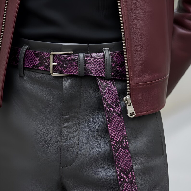 May include: A close-up of a purple snakeskin belt with a silver buckle, worn with black leather pants and a burgundy leather jacket. The belt is the focal point, showcasing its unique pattern and color.