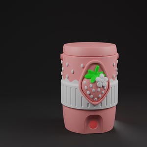 May include: A cylindrical pink container with a lid, featuring a white band around the center and a raised strawberry emblem with green leaves and a white flower. The upper portion of the container has a dotted texture, and a small circular opening is visible at the base.